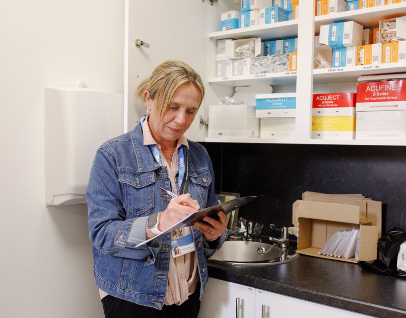 CDAS staff member with a clipboard in a clinical room at CDAS, Whittle Court
