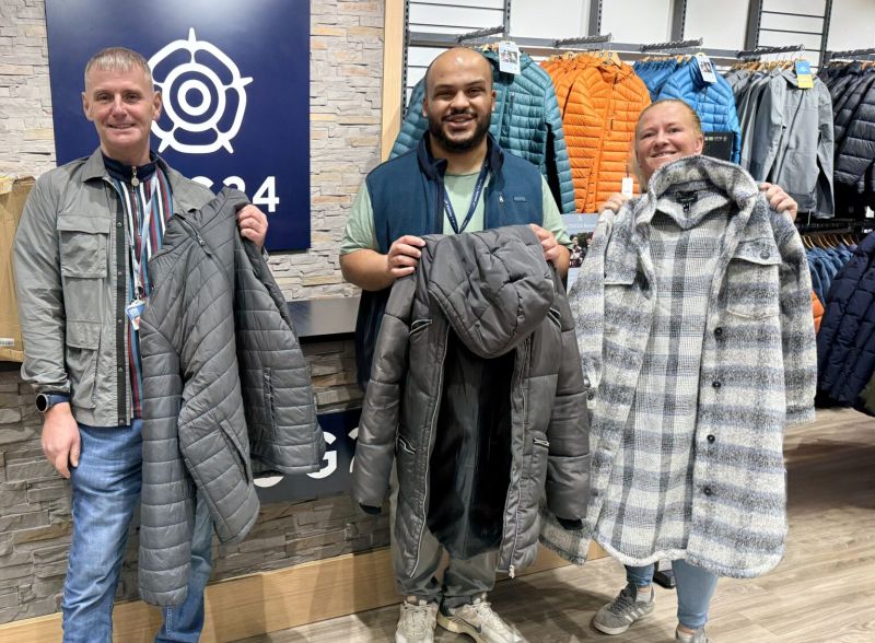 People holding up coats